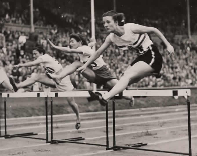 woman jumping over hurdle