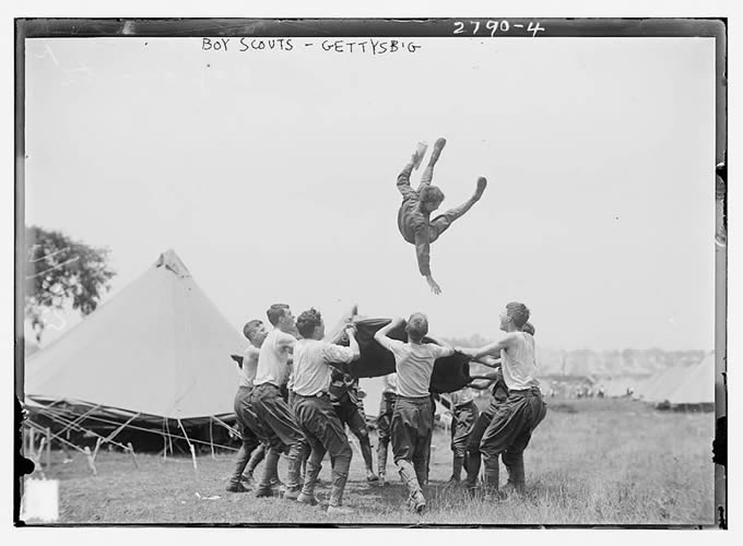 boys tossing boy in air with blanket